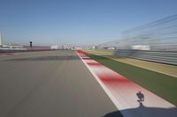 the red line is in motion on the track, with blurred background and blurry images of man driving it