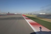 the red line is in motion on the track, with blurred background and blurry images of man driving it