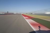the red line is in motion on the track, with blurred background and blurry images of man driving it