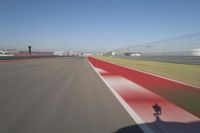 the red line is in motion on the track, with blurred background and blurry images of man driving it