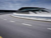 motion blur image of an empty road by buildings with sky background of blurry car coming on it