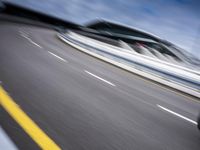 motion blur image of an empty road by buildings with sky background of blurry car coming on it