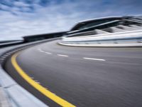 motion blur image of an empty road by buildings with sky background of blurry car coming on it