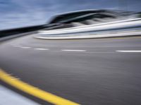 motion blur image of an empty road by buildings with sky background of blurry car coming on it