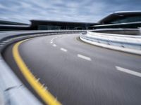 motion blur image of an empty road by buildings with sky background of blurry car coming on it