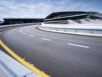 motion blur image of an empty road by buildings with sky background of blurry car coming on it