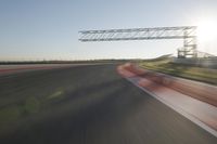 motion blurs down an airport runway and overhang the landing strip at sunrise with some clouds