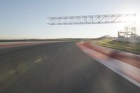 motion blurs down an airport runway and overhang the landing strip at sunrise with some clouds