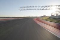 motion blurs down an airport runway and overhang the landing strip at sunrise with some clouds