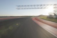 motion blurs down an airport runway and overhang the landing strip at sunrise with some clouds
