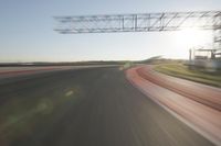 motion blurs down an airport runway and overhang the landing strip at sunrise with some clouds