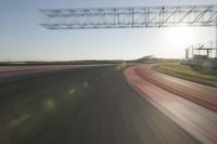 motion blurs down an airport runway and overhang the landing strip at sunrise with some clouds