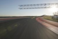 motion blurs down an airport runway and overhang the landing strip at sunrise with some clouds