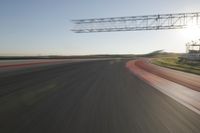 motion blurs down an airport runway and overhang the landing strip at sunrise with some clouds