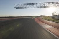 motion blurs down an airport runway and overhang the landing strip at sunrise with some clouds