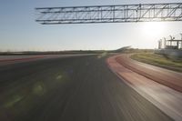 motion blurs down an airport runway and overhang the landing strip at sunrise with some clouds