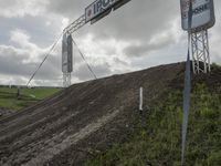 a dirt bike rider goes up a hill, making a big jump in a race track