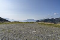 a motorcycle parked on a small mountain side road near mountains with no cars driving on it