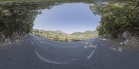 an image taken from inside a convex lens of a motorcycle going down a winding road