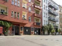 a motorcycle is driving along a city street near large buildings and gardens and greenery