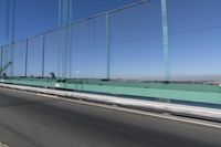 a person driving a motorcycle on a bridge on a blue day, the blurry bridge is in the background