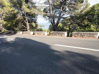 a motor cycle is seen on the road in front of a mountain and ocean view