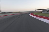 a person on a motorcycle is going through the curve on a race track under an overpass