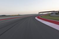 a person on a motorcycle is going through the curve on a race track under an overpass