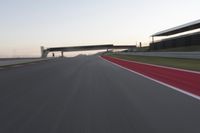 a person on a motorcycle is going through the curve on a race track under an overpass