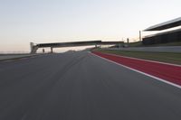 a person on a motorcycle is going through the curve on a race track under an overpass