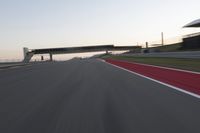 a person on a motorcycle is going through the curve on a race track under an overpass