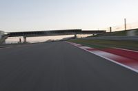 a person on a motorcycle is going through the curve on a race track under an overpass