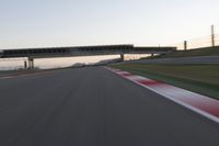 a person on a motorcycle is going through the curve on a race track under an overpass