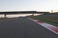 a person on a motorcycle is going through the curve on a race track under an overpass