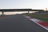 a person on a motorcycle is going through the curve on a race track under an overpass