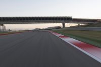 a person on a motorcycle is going through the curve on a race track under an overpass