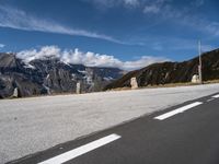 a motorcycle on the road by a road sign and mountain view with snow capped mountains in the distance