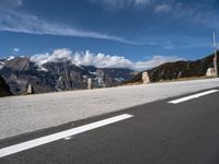 a motorcycle on the road by a road sign and mountain view with snow capped mountains in the distance