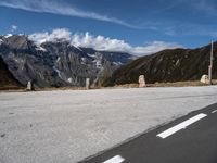 a motorcycle on the road by a road sign and mountain view with snow capped mountains in the distance