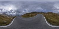 a motorcycle driving down a curve in the road as seen in the mirror of a fish eye view