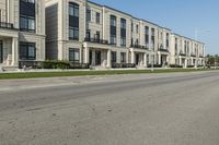 a man rides a motorcycle down a road with two apartment buildings behind him on either side