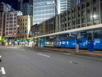 a person is riding a motorcycle down a city street at night time, with lots of tall buildings