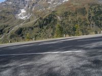 a person rides a motorcycle on the road near a mountain side and the camera is out