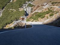 a man is riding his motorcycle down a mountain road with green trees in the background