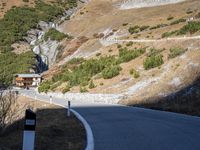 a man is riding his motorcycle down a mountain road with green trees in the background