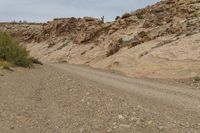 a person riding their motorcycle down a mountain side road by itself a small patch of dirt