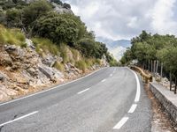 motorcycle riding along a winding mountain road on a sunny day from a distance from the vehicle