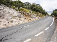 motorcycle riding along a winding mountain road on a sunny day from a distance from the vehicle