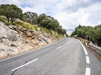 motorcycle riding along a winding mountain road on a sunny day from a distance from the vehicle
