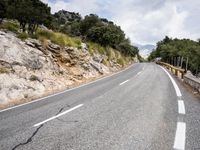 motorcycle riding along a winding mountain road on a sunny day from a distance from the vehicle